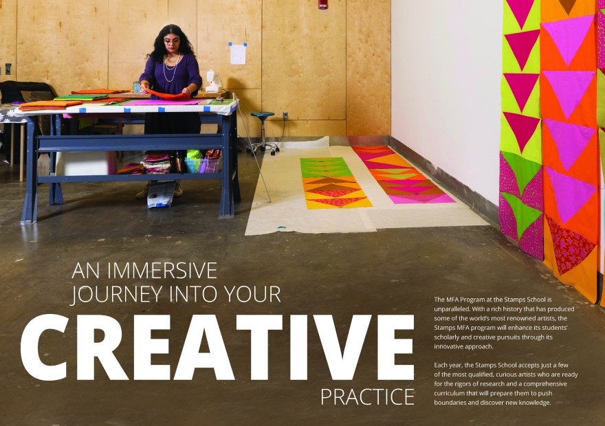 A graduate art student stands at a large worktable in a studio, arranging colorful fabric pieces for a quilt project. The workspace features wooden walls, a sewing machine, and bright geometric fabric panels in pink, orange, green, and yellow tones spread across the floor and pinned to the wall. Large white text overlays the image reading, “An immersive journey into your creative practice.” To the right, smaller text describes the Stamps School of Art & Design MFA program, highlighting its focus on innovation, research, and creative exploration. The overall scene conveys an atmosphere of focused artistry and vibrant experimentation.